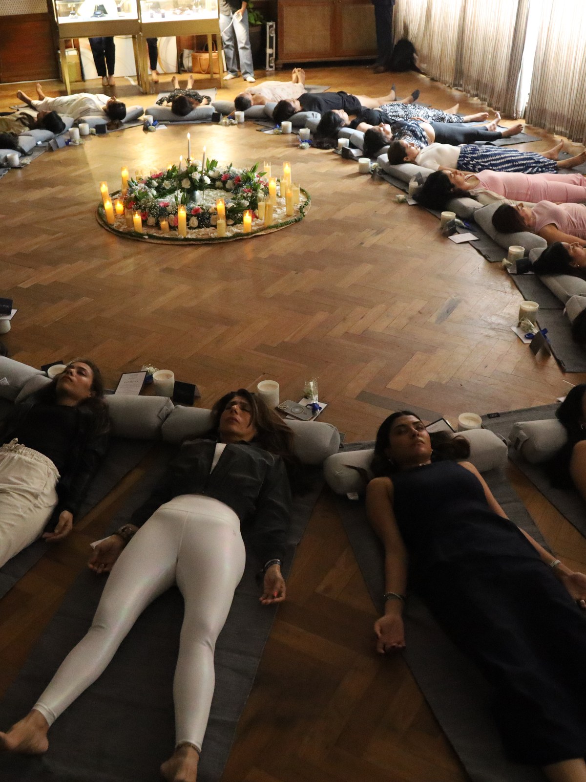 Guests lying down around the candle and floral ring, Forevermark by De Beers morning at Soho House Mumbai